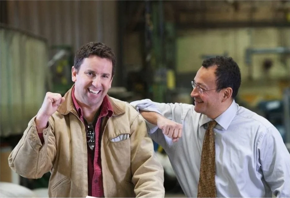 Two coworkers sharing an encouraging moment in a warehouse