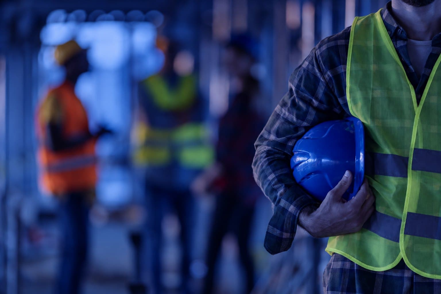 A worker holding a hard hat before the shift